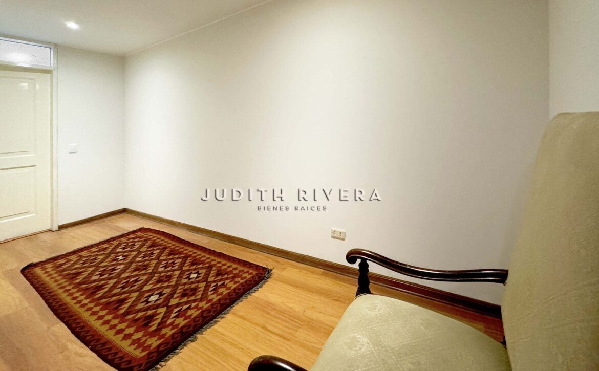 Sala del departamento en venta en San Isidro con piso de madera
