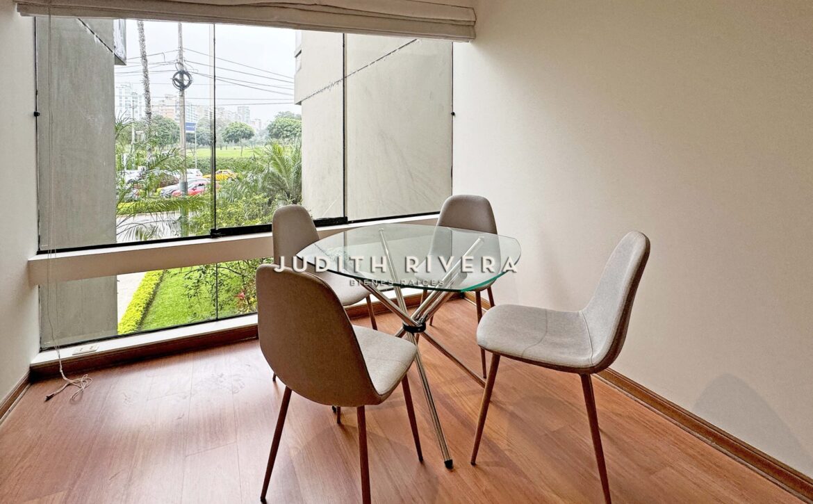 Comedor con mesa de vidrio y vista al Golf de San Isidro