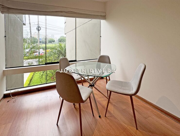 Comedor con mesa de vidrio y vista al Golf de San Isidro