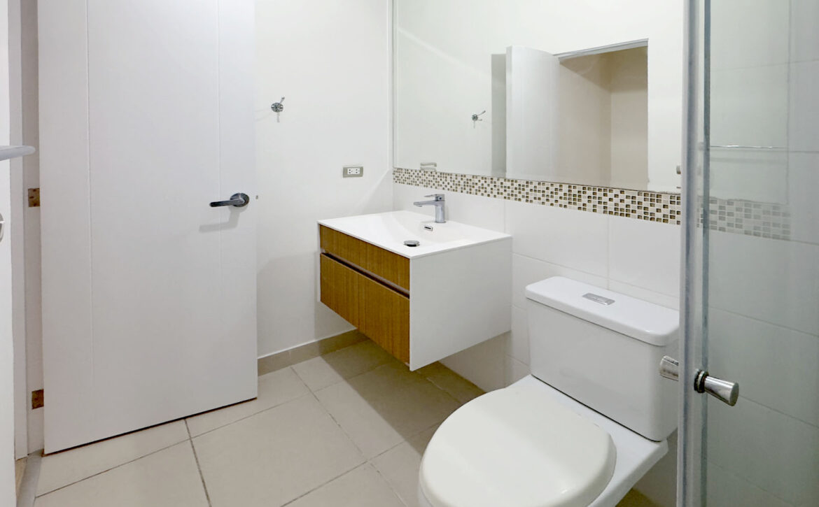 Baño con mueble vanitorio flotante y espejo, departamento en venta en Lince