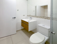 Baño con mueble vanitorio flotante y espejo, departamento en venta en Lince