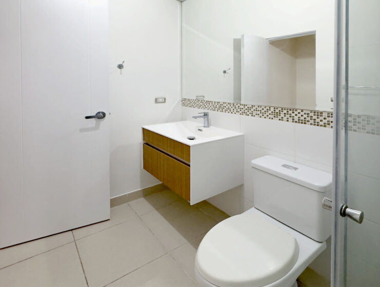 Baño con mueble vanitorio flotante y espejo, departamento en venta en Lince