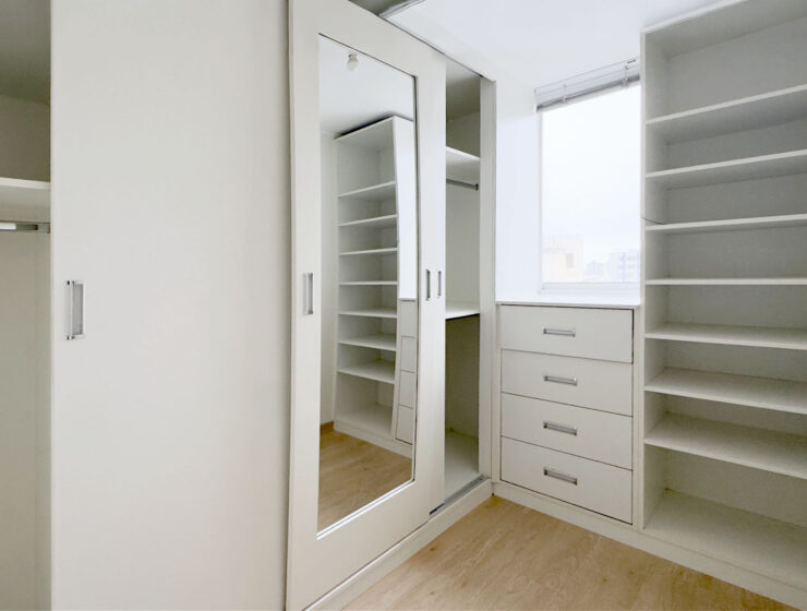 Walk-in closet del dormitorio principal con cajonera y espejo, departamento en venta en Lince