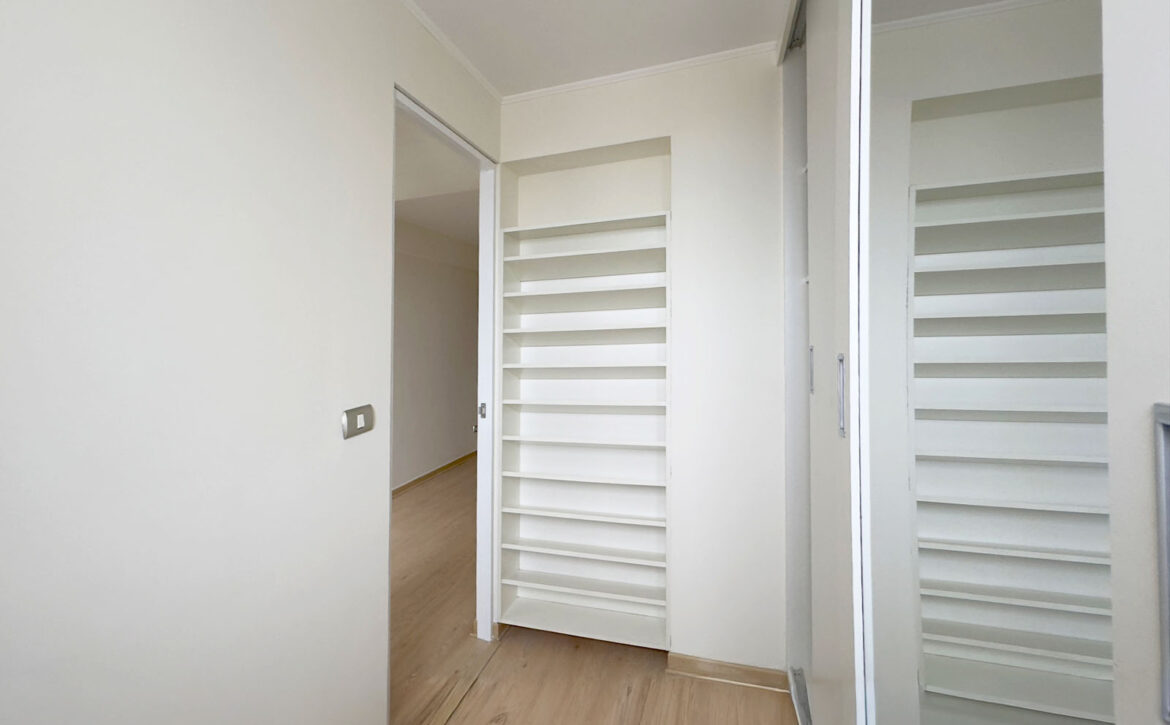 Vestidor del dormitorio principal con repisas y ventana, departamento en venta en Lince