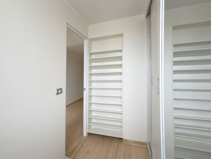 Vestidor del dormitorio principal con repisas y ventana, departamento en venta en Lince