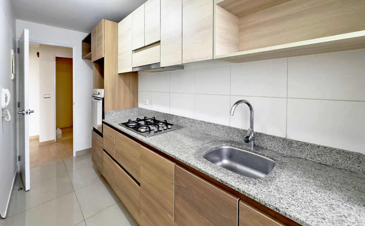 Detalle de cocina equipada con muebles altos y bajos, departamento en venta en Lince