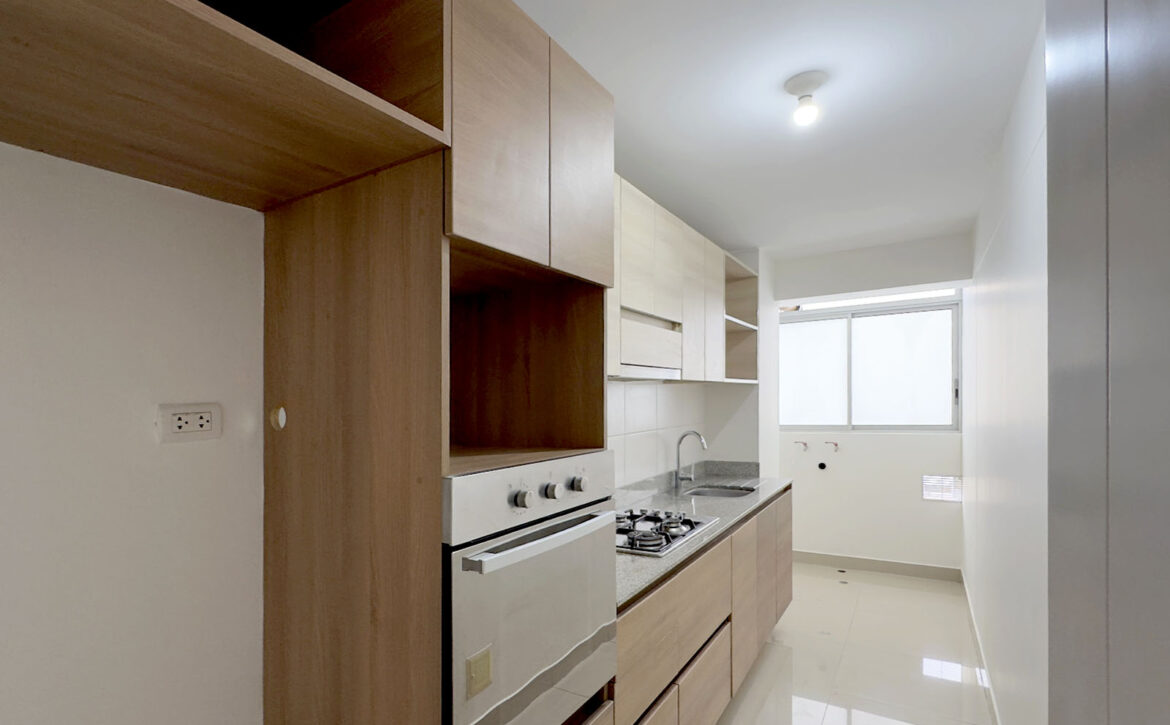 Cocina cerrada equipada con cocina a gas y horno empotrado, departamento en venta en Lince