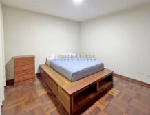 Dormitorio del departamento en alquiler en Surco, con cama, cómoda de madera y paredes claras.