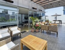 Terraza común con mesas y sombrillas del edificio, oficina en alquiler en San Isidro