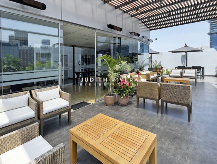 Terraza común con mesas y sombrillas del edificio, oficina en alquiler en San Isidro