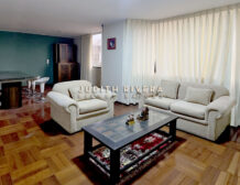 Sala comedor amoblada del departamento en alquiler en Santiago de Surco, con sofás claros, mesa de centro y piso de madera.