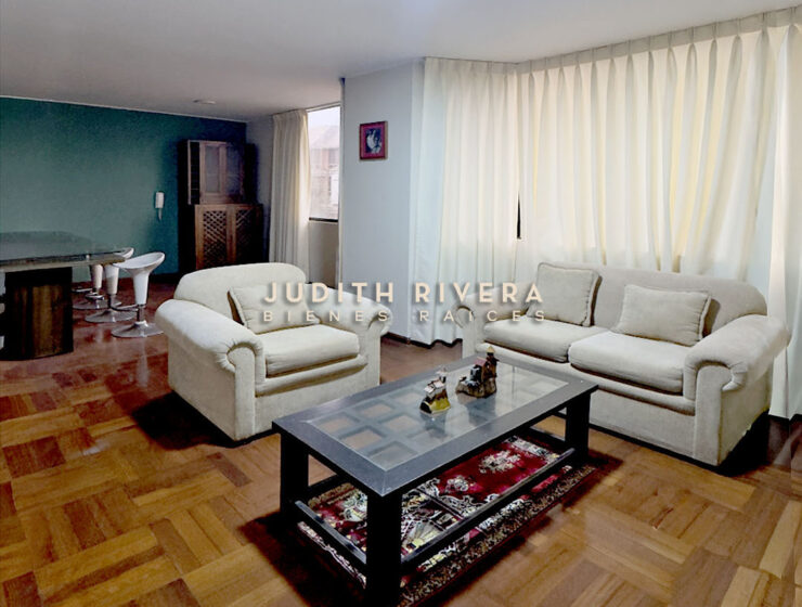 Sala comedor amoblada del departamento en alquiler en Santiago de Surco, con sofás claros, mesa de centro y piso de madera.
