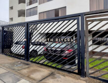 Cochera del edificio del departamento en alquiler en Santiago de Surco, con reja metálica.