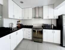 Cocina con muebles blancos, tablero negro, campana de acero y horno empotrado