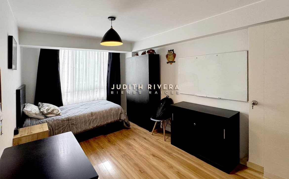 Dormitorio con cama de dos plazas, clóset, cómoda y pizarra en la pared