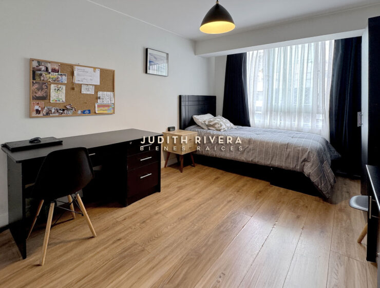 Dormitorio con escritorio de trabajo, cama de dos plazas y ventana amplia con cortinas