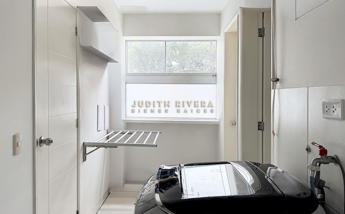 Lavandería con ventana, tendedero de pared y espacio para lavadora