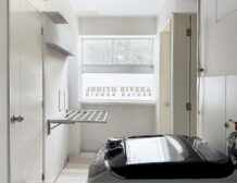 Lavandería con ventana, tendedero de pared y espacio para lavadora