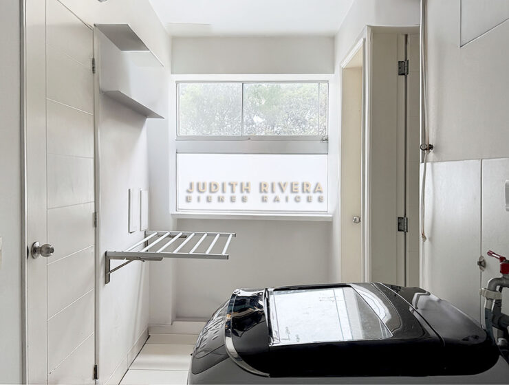 Lavandería con ventana, tendedero de pared y espacio para lavadora