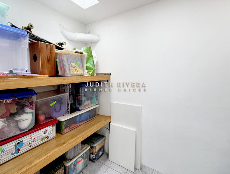 Ambiente con repisas de madera, piso de cerámica y claraboya